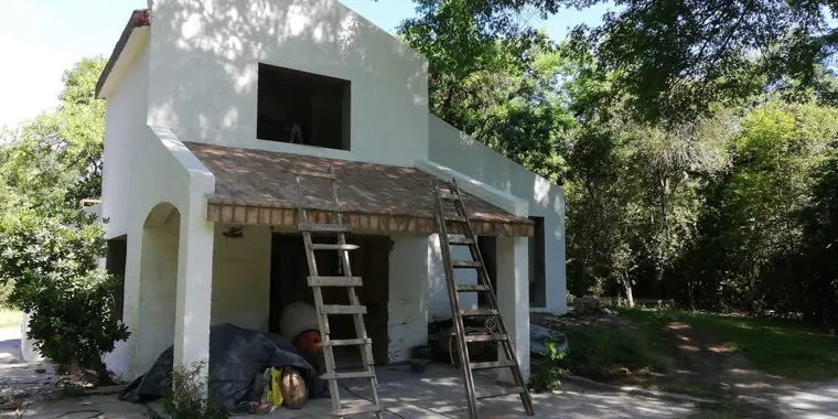 La casa durante la obra: el frontón abierto y las escaleras apoyadas sobre el mismo techo de tejas de la galería